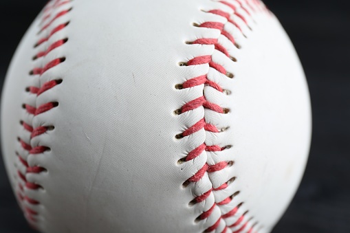 White leather baseball poses on black background