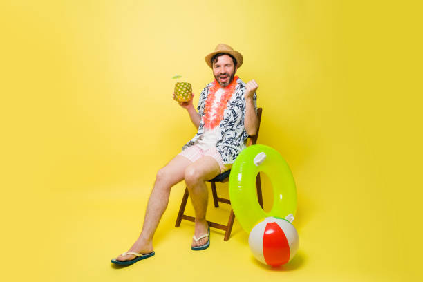 istock Handsome cheerful man drinking a pineapple drink and relaxing 1490814154