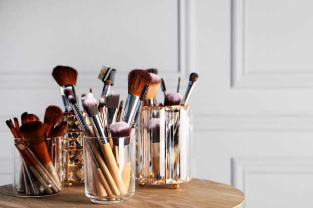 istock Set of professional makeup brushes on wooden table, space for text 1490814174