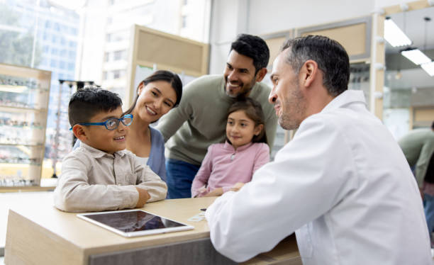 istock Happy boy talking to the optician while wearing his new glasses 1490814512