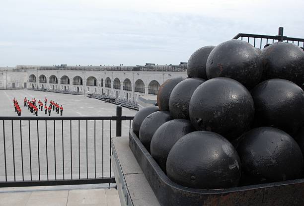 Fort Henry, ON looking over Fort Henry parade square, focus on canon balls with band in the background kingston ontario photos stock pictures, royalty-free photos & images