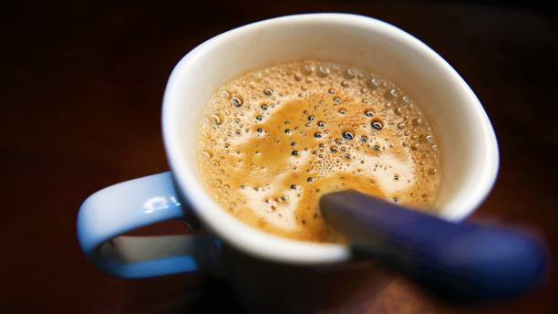 eine kaffeetasse auf dem tisch. löffel in einer kaffeetasse. instant-kaffeetasse. kaffee trinken. heißer kaffee - snack coffee instant coffee cappuccino stock-fotos und bilder