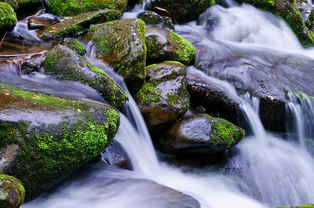 water flowing through rocks stock photo