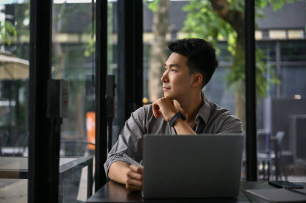 istock Inspired Asian businessman thinking and daydreaming while looking out the window 1490828713
