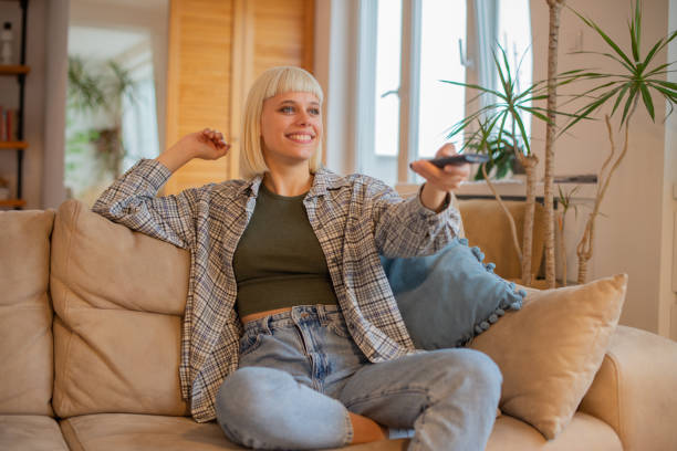 Woman enjoying her favorite TV show at home stock photo