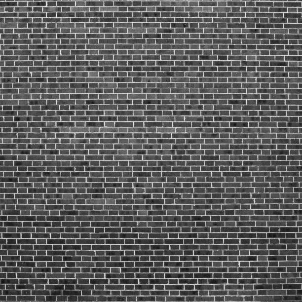 istock Grayscale backdrop with old realistic black brick wall. Minimal fragment of brickwall close-up. Minimalist monochrome background with wall of gray bricks in different shades. Simple wall texture. 1490831859