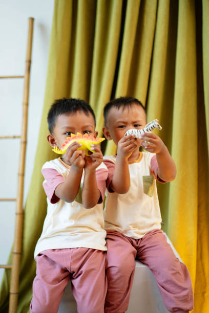 istock Two Boys Todler Studio Portrait Playing with Dinosaur Toys 1490835592