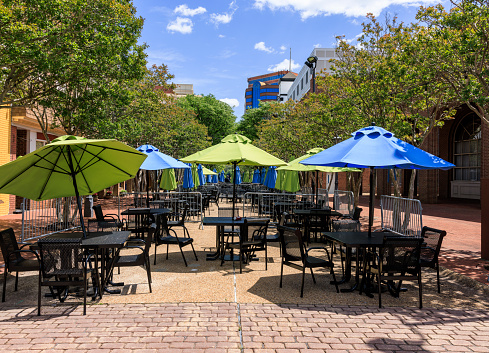 Side walk cafe with green and blue umbrellas as sunshade, weekend leisure activity in Downtown, E Queens Wy Str, Hampton, Virginia, USA