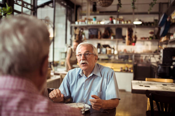 istock Two senior friends having a conversation at a local small restaurant 1490837439
