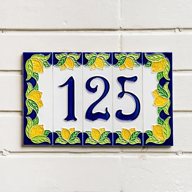 house number hundred and twenty-five on ceramic tiles surrounded by a decoration of lemons
