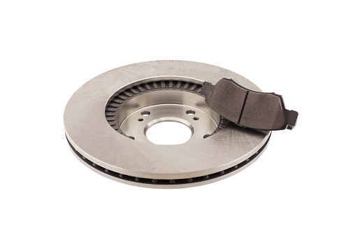 Car brake disc and brake pads isolated on white background. Auto spare parts - brake disc rotor and pads