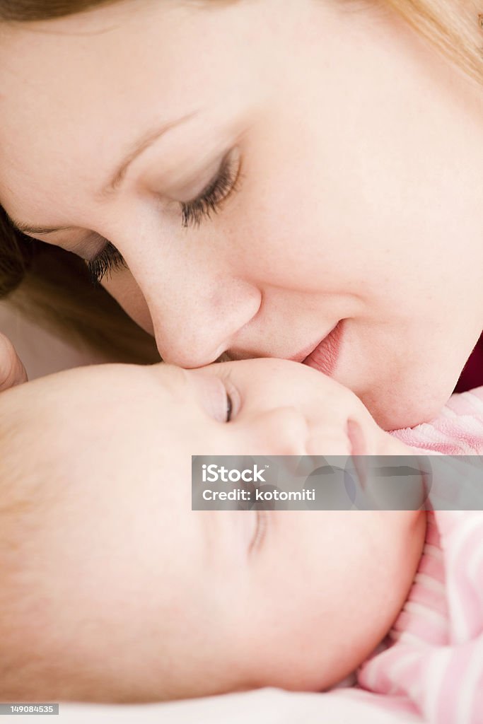 Mother and the small child Young mum embraces the falling asleep chest babyYoung mum holds on hands of the chest baby 0-11 Months Stock Photo