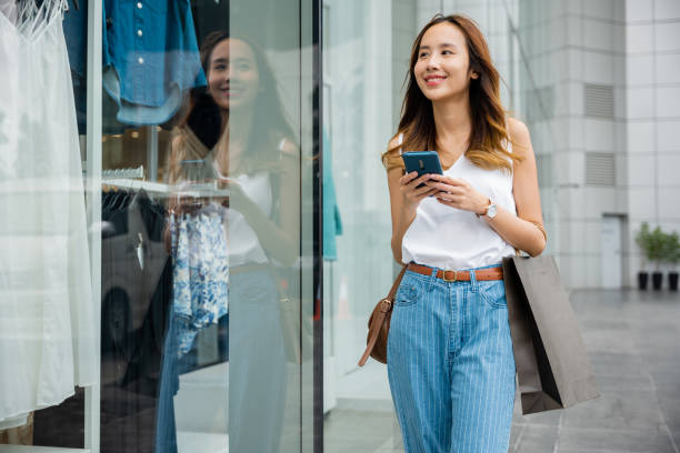 istock person looking at her phone while standing against a city wall 1490847024