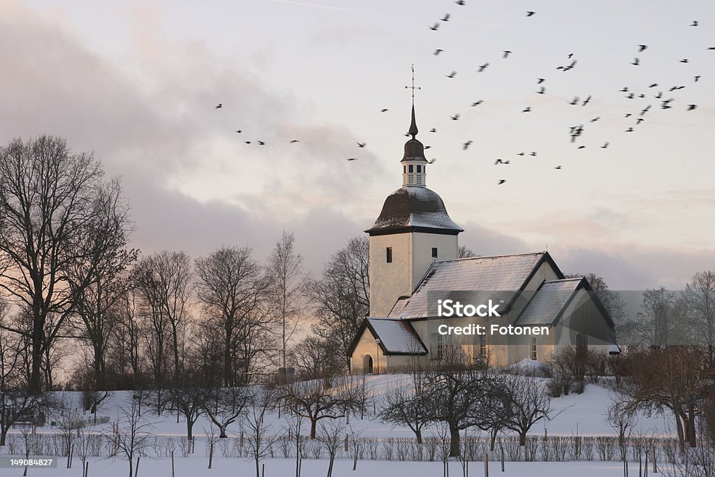 Church An old Swedish country church surrounded by a winter landscape at dusk with a flock of birds flying by. Church Stock Photo