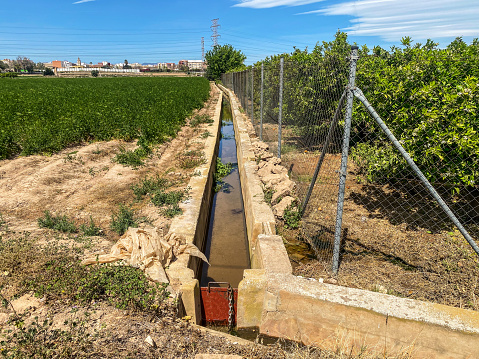 Long and narrow irrigation ditch used to water local orchards in the Valencian Community, Spain