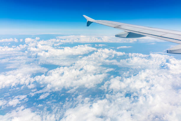 istock View from the airplane window at a beautiful cloudy sky and the airplane wing 1490849320