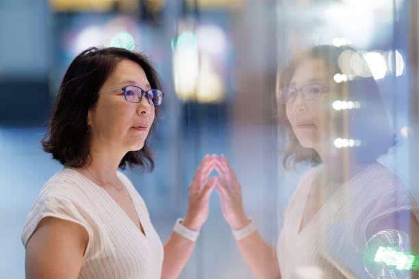 istock Woman looking in a shop window at night 1490855493
