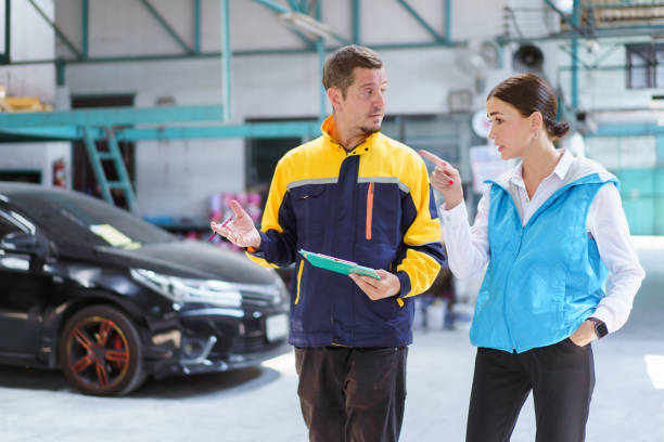 istock Woman and technician talking together in garage. 1490856367