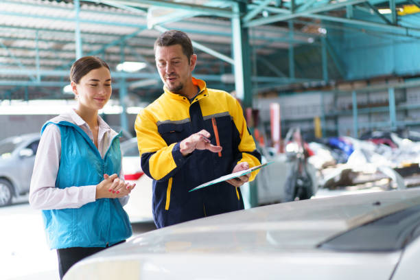 Woman and technician talking together in garage.