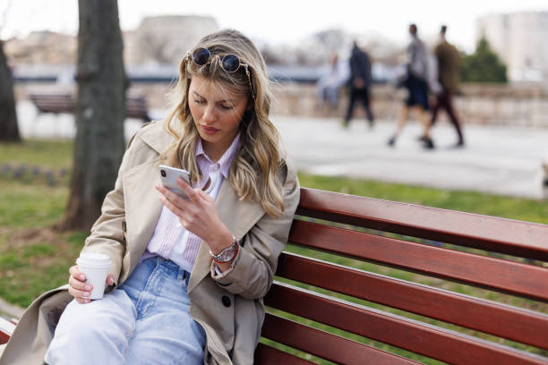 istock Young woman drinking takeaway coffee while relaxing on park bench 1490857977