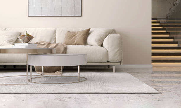 istock Two layer round white top coffee table, cream corner sofa on gray shag rug, marble floor, wooden stairway, LCD hidden light in sunlight on beige wall luxury living room 1490858059