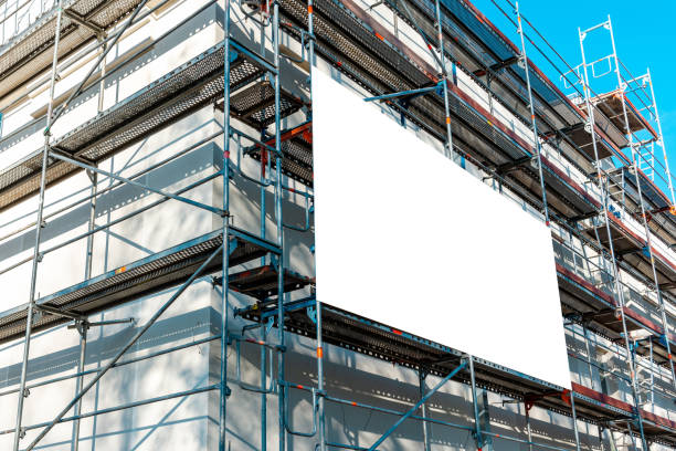 istock Blank white advertisement hanging on the scaffolding of modern building under construction.Reconstruction of a building with white billboard. 1490858892