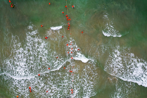 Aerial view of tourist wearing life jacket and surfing