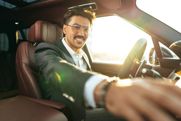 istock Young businessman in elegant suit driving luxury car 1490875862