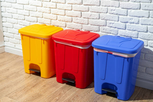 istock Three plastic trash bins against the wall in the building 1490877309