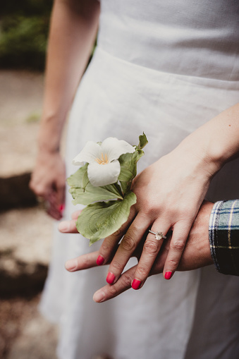 Diamond engagement ring with hands held by couple