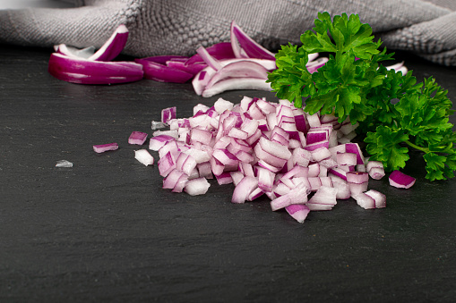 Red Onion Cuts, Raw Purple Onion Slices, Chopped Purple Onion Pieces on Black Rustic Table Background Closeup