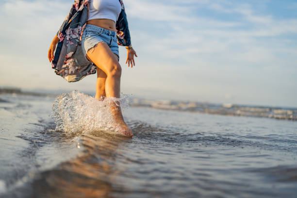 Woman legs walking on beach