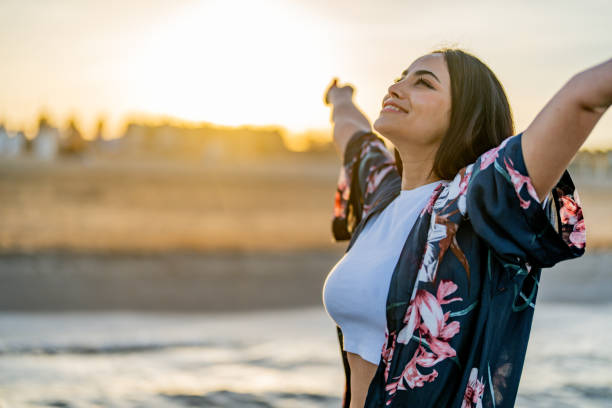 istock Young woman standing in meadow with with arms outstretched 1490881852