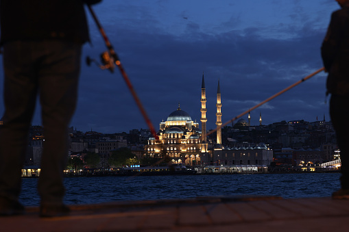 Istanbul, Turkey - May 17, 2022. Fishermen on the Galata Bridge, famous fishing road in the center of Istanbul, Turkey