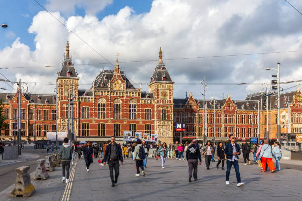 Amsterdam, the Netherlands - May 16th, 2023: Public transport at Amsterdam Central Station. Lot's of persons are walking from and towards the central station.