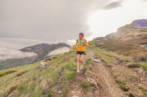 Female trail running on mountain trail