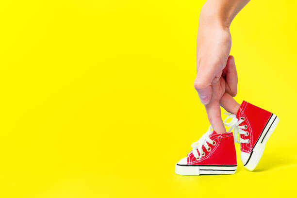 istock Hand Fingers Walking in Red Sneakers on Yellow 1490885823
