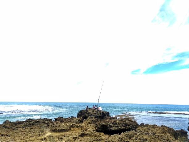istock three young men fishing ashore on a coral reef 1490886269