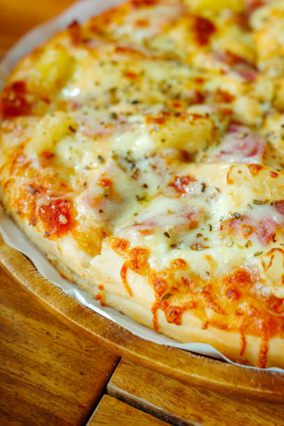 Close focus on homemade Hawaiian pizza covered after baking from oven.