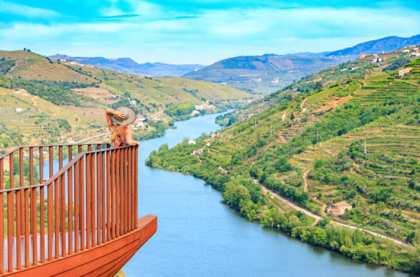 Woman tourist at balcony viewpoint admiring panoramic view of Douro valley in Portugal stock photo