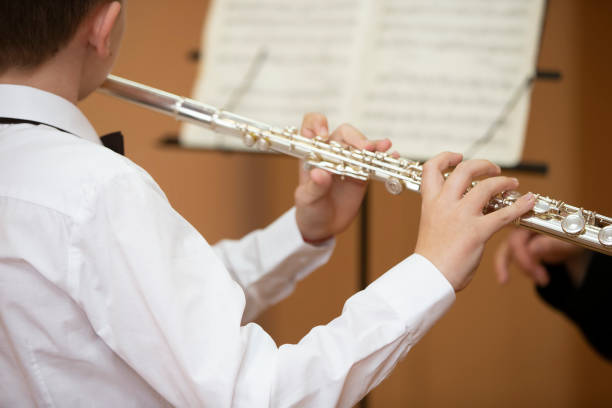 istock The boy plays the shining flute. Wind musical instrument. 1490895649