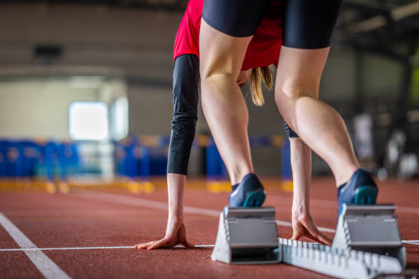 runner standing on starting block at track - hurdling hurdle running track event imagens e fotografias de stock