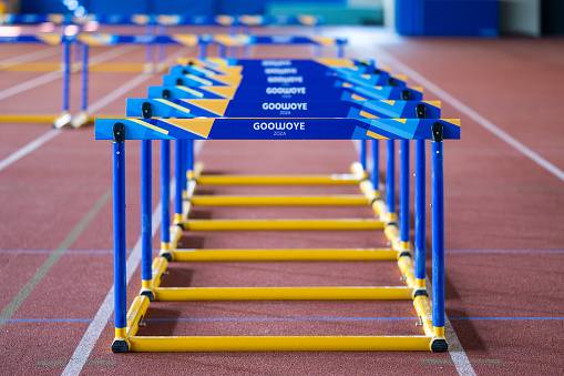 Blue and yellow hurdles at stadium running track for training close up