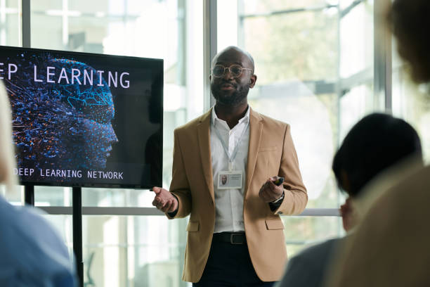 istock Young black man in formalwear standing by interactive board during presentation 1490896190