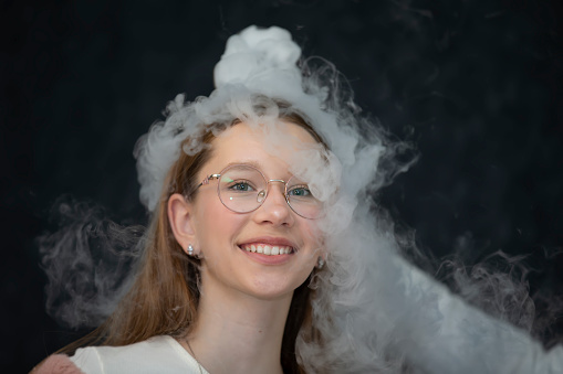 The child is a participant in scientific experiments. Girl in liquid nitrogen smoke.