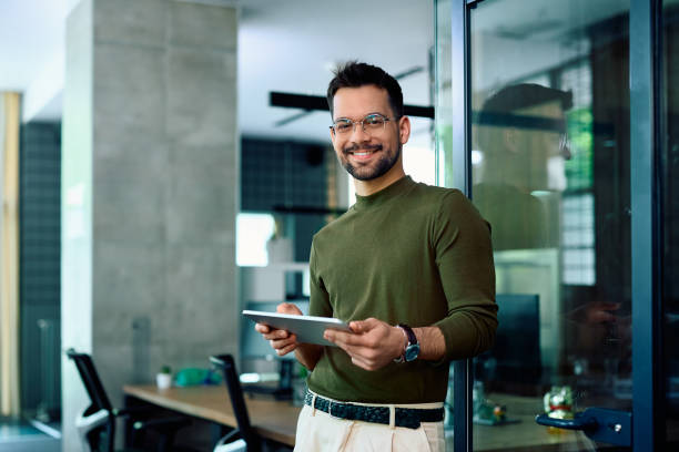istock Happy entrepreneur using digital tablet in the office and looking at camera. 1490898168