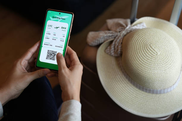 istock A close-up image shows a woman holding a smartphone displaying an electronic flight ticket as she completes an online check-in for her vacation. 1490898349