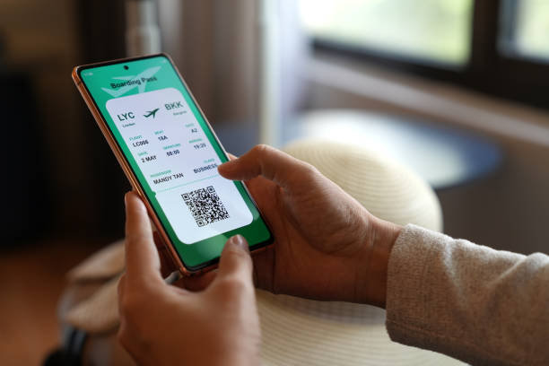 istock A close-up image shows a woman holding a smartphone displaying an electronic flight ticket as she completes an online check-in for her vacation. 1490898466