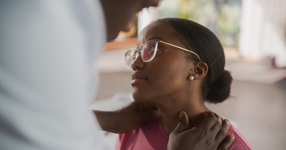 Black Physician Inspect Neck Muscles For Any Damages of a Female African Patient During a Recovery Check Up Visit to a Clinic. Doctor Working in Modern Hospital Office