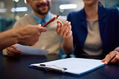 Close up of couple about to sign a contract with bank manager.